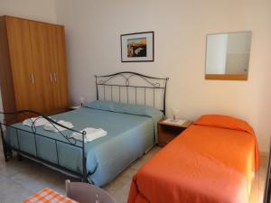 1 dormitorio con 1 cama y 1 reposapiés naranja en B&B Villa Teresa, en Lecce