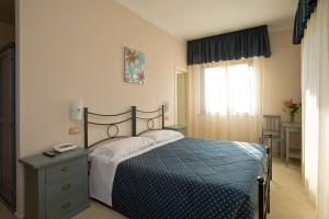 a bedroom with a bed and a table and a window at Villa Hotel Del Sole in Chiusi