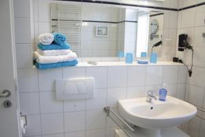 une salle de bain avec un lavabo, un miroir et des serviettes dans l'établissement Villa Concordia Apartment Hiddensee, à Binz 15 autres photos