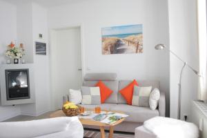 un salon avec un canapé et une table dans l'établissement Villa Concordia Apartment Hiddensee, à Binz