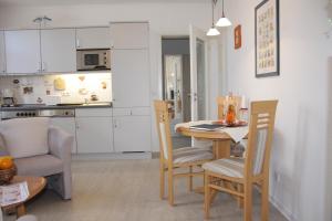 une cuisine et une salle à manger avec une table et des chaises dans l'établissement Villa Concordia Apartment Hiddensee, à Binz