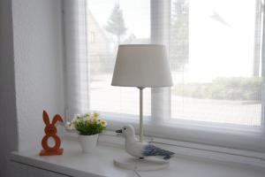 ビンツにあるVilla Concordia Apartment Hiddenseeの窓際のテーブルに座る灯