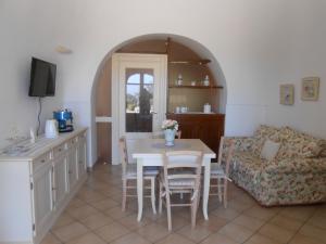 cocina y sala de estar con mesa y sofá en B&B La Collina Degli Ulivi, en Fasano