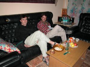 two men are sitting on a leather couch at Islambek Hotel & Travel in Khiva