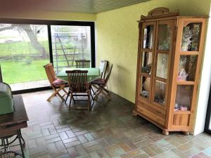 ein Esszimmer mit einem Tisch und Stühlen sowie einem Schrank in der Unterkunft Ferienwohnung Familie Ober in Rotthalmünster