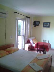 a bedroom with two beds and a tv and a window at Guesthouse Lautasevic in Petrovac na Moru
