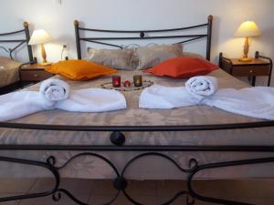 uma cama com duas toalhas e uma bandeja com velas em Agapi Villas em Karterados