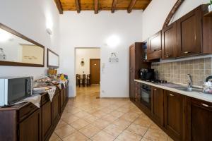 Il comprend une grande cuisine avec des placards en bois et du carrelage. dans l'établissement B&B Addauru, à Palerme