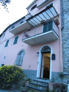 Edificio blanco con balcón y puerta en Casa Antica Rosetta, en Dolcedo