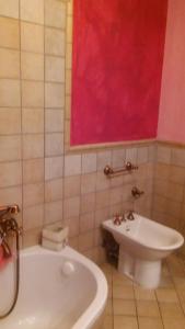 een badkamer met een bad, een toilet en een wastafel bij B&B PinkHouse in Milazzo