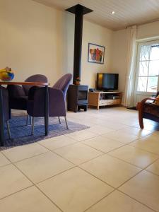 sala de estar con mesa, sillas y TV en Glafsfjordens Accommodatie, en Arvika
