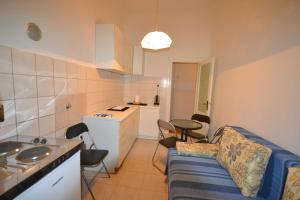 Una sala de estar con un sofá y una cocina. en Apartment Porto Baross, en Rijeka