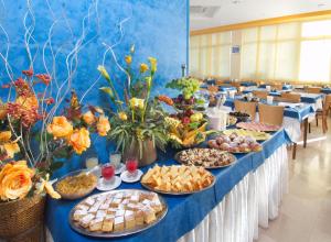 a long table with many plates of food on it at Hotel caesar in Cattolica +17 photos