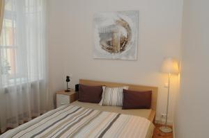 プラハにあるRoyal Road Apartmentのベッドルーム1室(ベッド1台付)が備わります。壁に絵が飾られています。