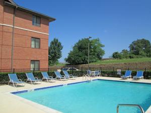 a swimming pool with lounge chairs and a building at Baymont by Wyndham Bedford-Dallas in Bedford