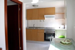 uma cozinha com armários de madeira e uma tigela de fruta numa mesa em Duplex na Nazaré na Nazaré