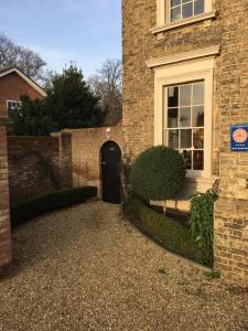 a brick house with a door and a bench in front of it at The Old Rectory in King's Lynn