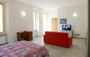 un soggiorno con divano rosso e TV di Appartamenti Medioevo a Varese