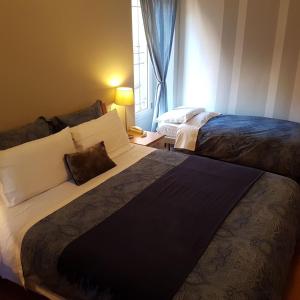 a hotel room with two beds and a window at Hotel Moniga in Desenzano del Garda