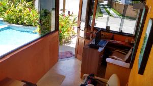 an office with a desk and a computer next to a swimming pool at Pousada Mareilha in Ilhabela