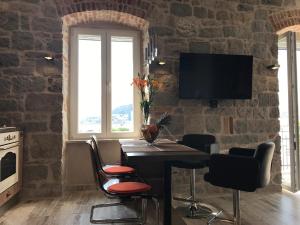 eine Küche mit einem Tisch mit Stühlen und einem TV an einer Backsteinwand in der Unterkunft Luxury Apartment Valentina in Split