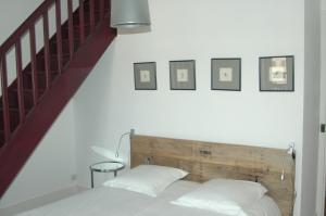 a bedroom with a bed with a wooden headboard and a staircase at Le Clos de l'Abbaye in Cluny