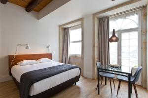 a bedroom with a bed and a table and a desk at RVA - Sao Joao Novo Apartments in Porto