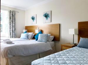 a hotel room with two beds with blue pillows at Hartford Court in Bournemouth
