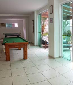 a pool table in the middle of a room at Apto Portal das Palmeiras in Ubatuba