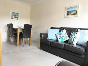 a living room with a black couch and a table at Hartford Court in Bournemouth