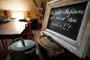 a chalkboard in a room with a table and two pots at Le Clos de l'Abbaye in Cluny