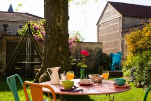 una mesa rosa con bebidas en un patio en Le Clos de l'Abbaye, en Cluny