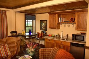 a kitchen with a counter and a table with chairs at The Mountain Top Inn & Resort in Chittenden