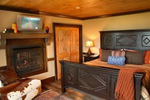 a bedroom with a bed with a fireplace and a television at The Mountain Top Inn & Resort in Chittenden