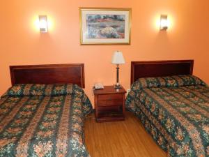 une chambre d'hôtel avec deux lits et un téléphone sur une table dans l'établissement Hotel Vicenza, à Monmouth Junction