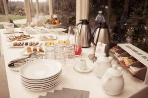 una mesa blanca con platos y platos. en Agriturismo Humile en Chianciano Terme