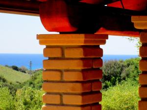 a view of the ocean from a brick wall at Sardinia Yellow House in Solanas