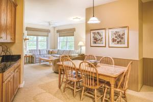 a dining room and living room with a table and chairs at Wyndham Smugglers Notch in Jeffersonville