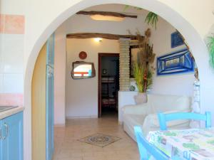 a living room with an archway with a couch and a table at Sardinia Yellow House in Solanas