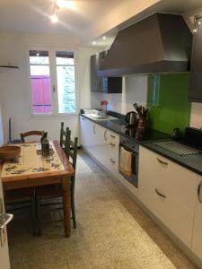una cocina con una mesa y una estufa horno superior en Maison les Ramparts, en Villefranche-de-Conflent
