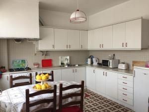 a kitchen with a table with a bowl of fruit on it at Lines of Wellignton in Torres Vedras