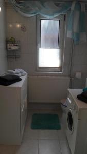 a bathroom with a washing machine and a window at Ferienhaus im Grünen/Monteurzimmer in Oranienburg +7 photos