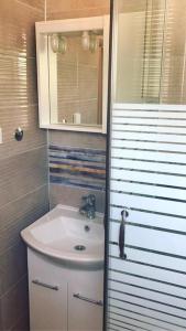 a small bathroom with a sink and a mirror at ALISA Sea View Apartment in Kotor