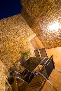 アルタにあるCasArtàの石壁前のテーブルと椅子