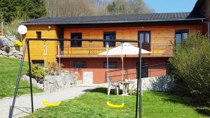 a swing set in a yard with a house at Gite du Walsbach in Munster