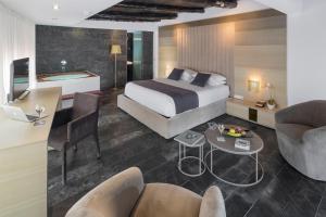 a hotel room with a bed and a table and chairs at Hotel Boutique Ses Pitreras in San Antonio Bay
