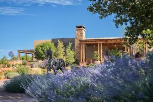 a garden with purple flowers in front of a house at Four Seasons Resort Rancho Encantado Santa Fe in Santa Fe