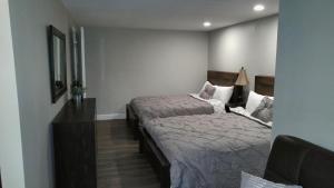 a bedroom with two beds and a table and a mirror at Lily's Lodge in West Springfield