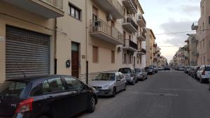 a row of cars parked on a street next to buildings at Calciufetta in Alghero