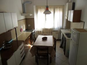 a kitchen with a table and a small kitchen with a window at Parri Apartment in Follonica